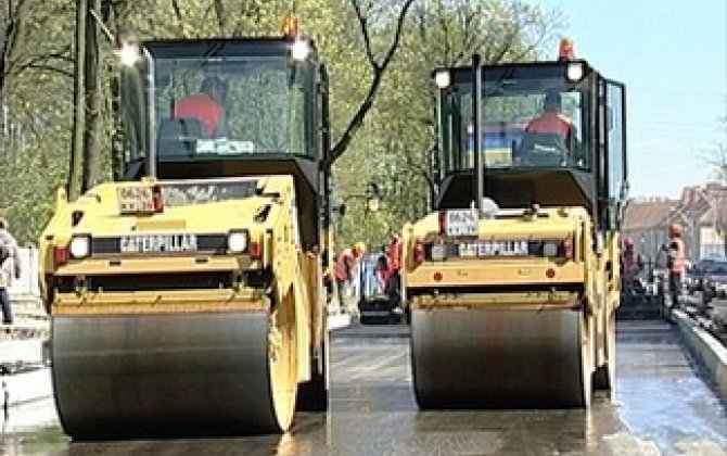 В Гяндже асфальтоукладчик опрокинулся на легковой автомобиль