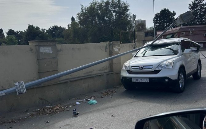 Bakıda külək işıq dirəyini aşırdı – avtomobilə ziyan dəydi